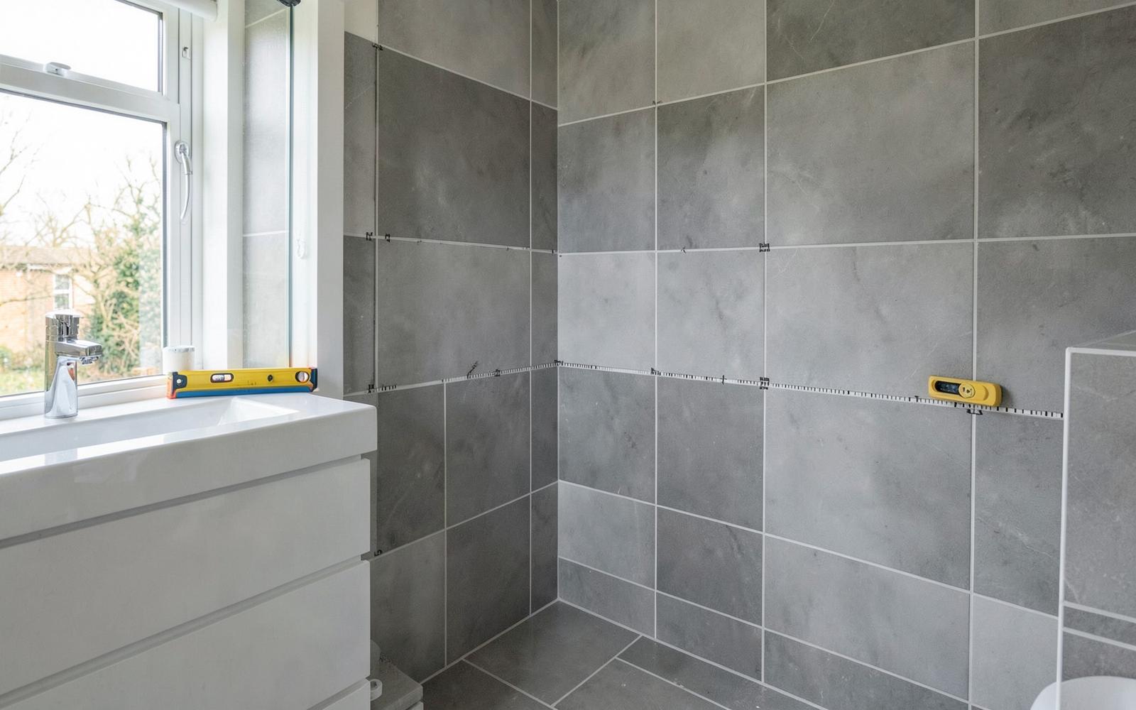 Large format wall tiles being fitted in a bathroom